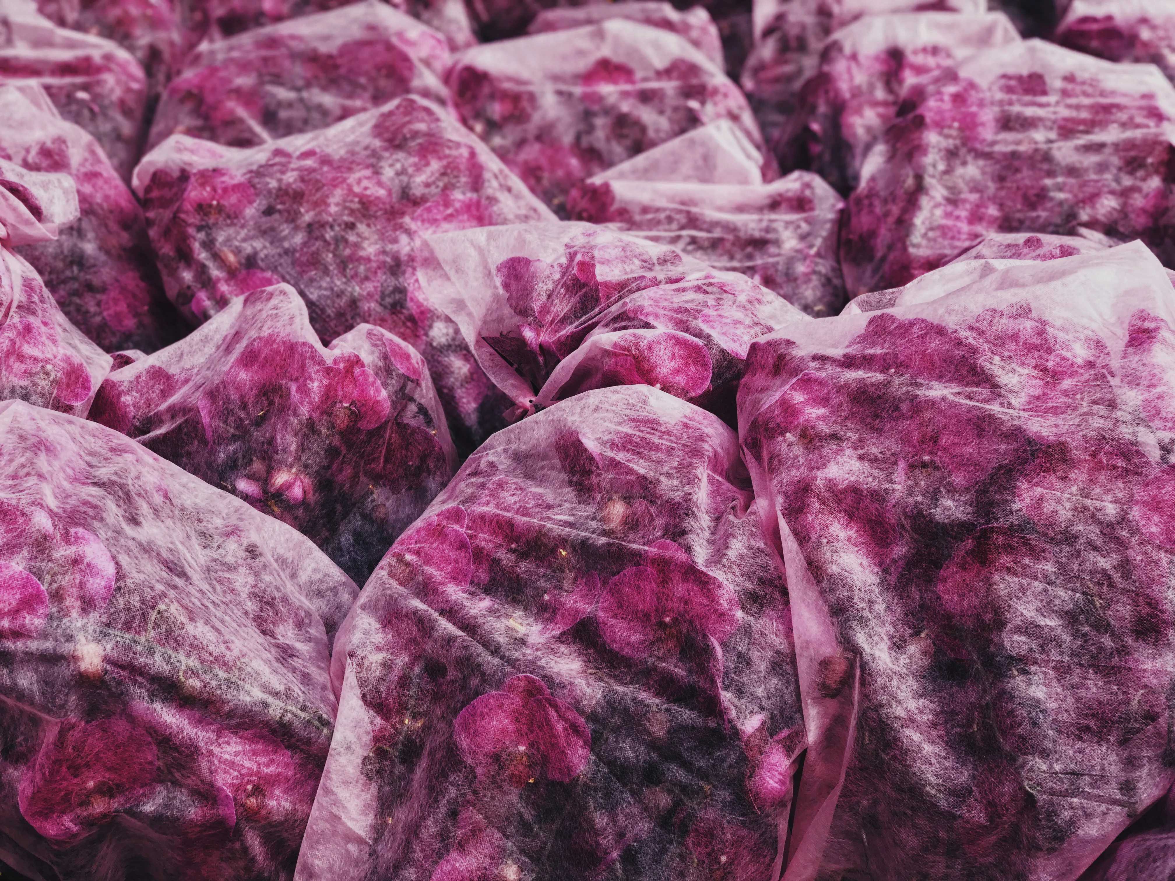 Close-up of pink and burgundy fabric-wrapped bundles with mottled texture, warm mood